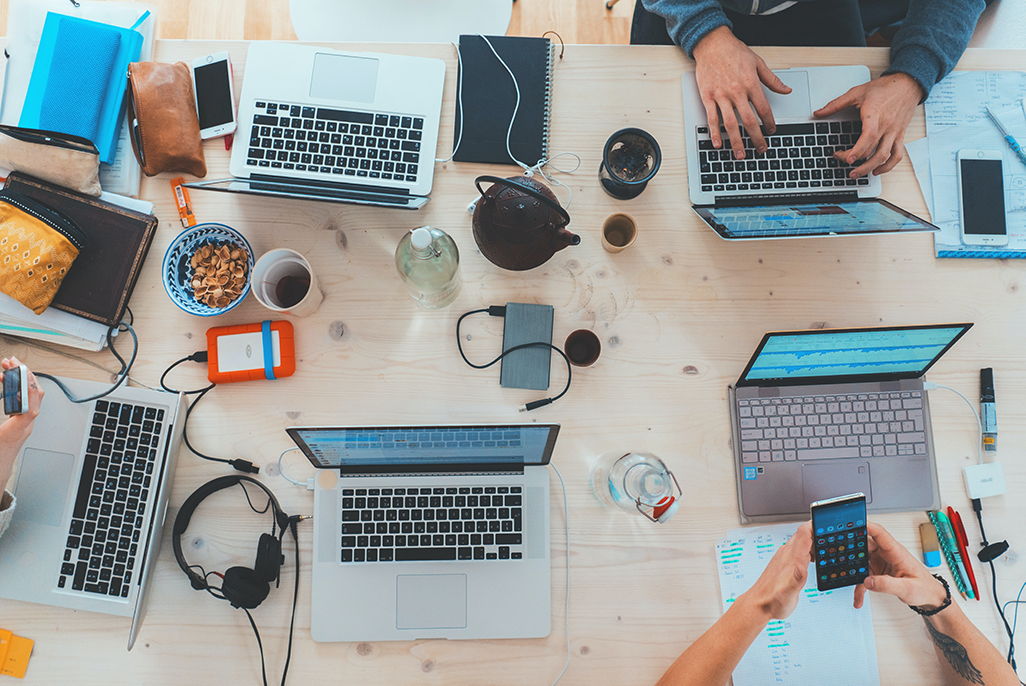 Una foto que muestra un comedor lleno de notebooks y cosas de trabajo de un equipo de migración